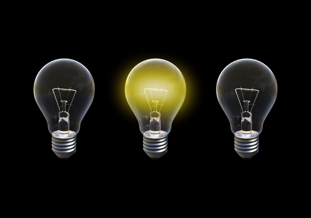 This is a picture of 3 light bulbs on a black background, the middle bulb is lit and it represents ideas, creativity and success.