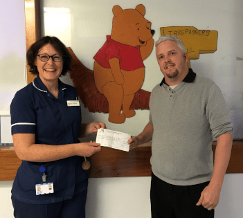Photo of one of our directors with a nurse from the neonatal department at Winchester hospital, receiving a donation from us.