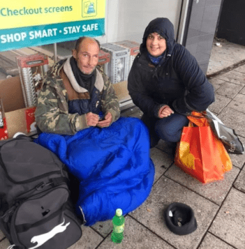 Photo of a homeless man with a volunteer after receiving a care package.
